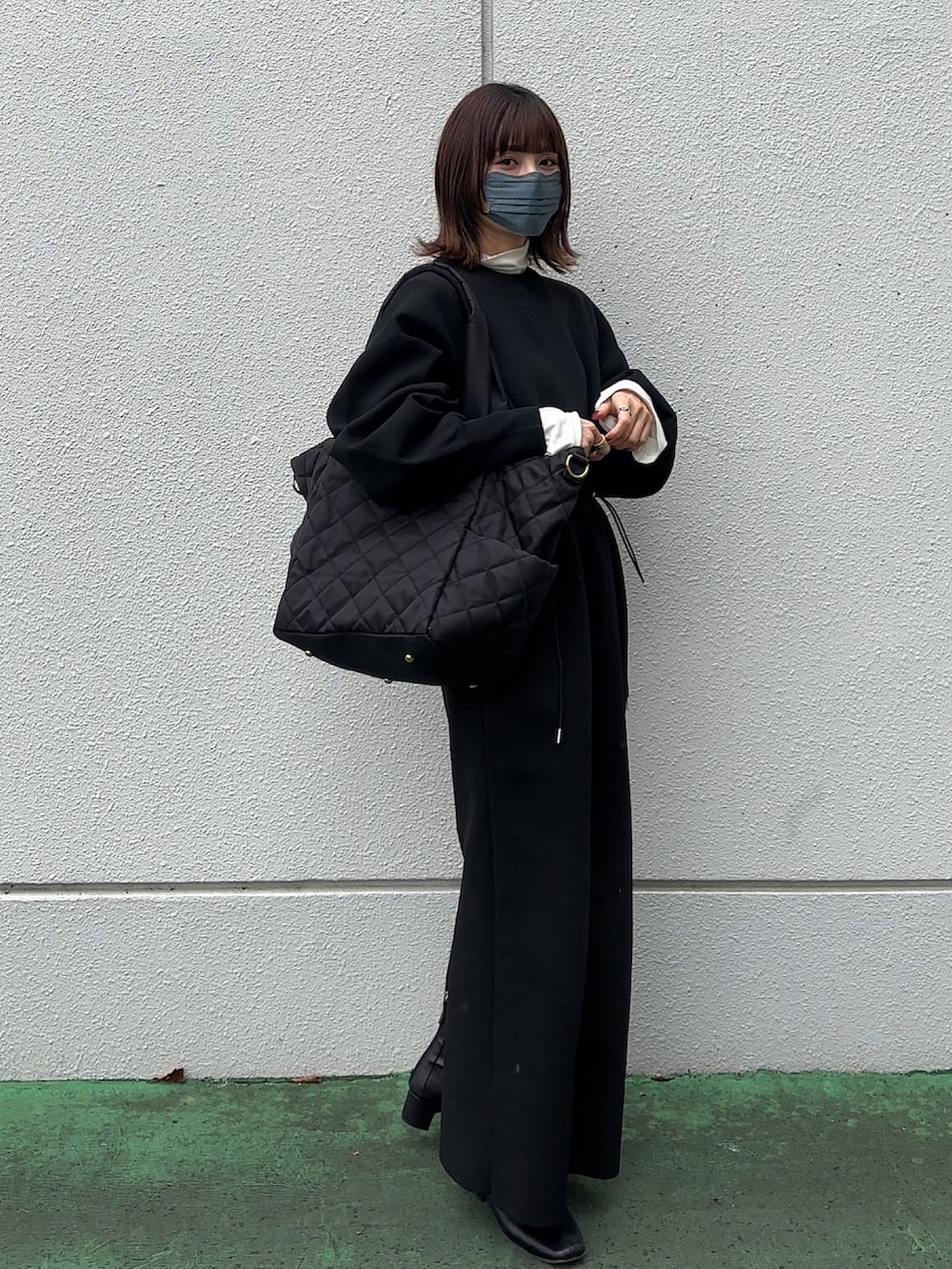ブラック系のワンピース、ブラック系のマザーズバッグを着用したレディースの冬コーディネートの3枚目の写真