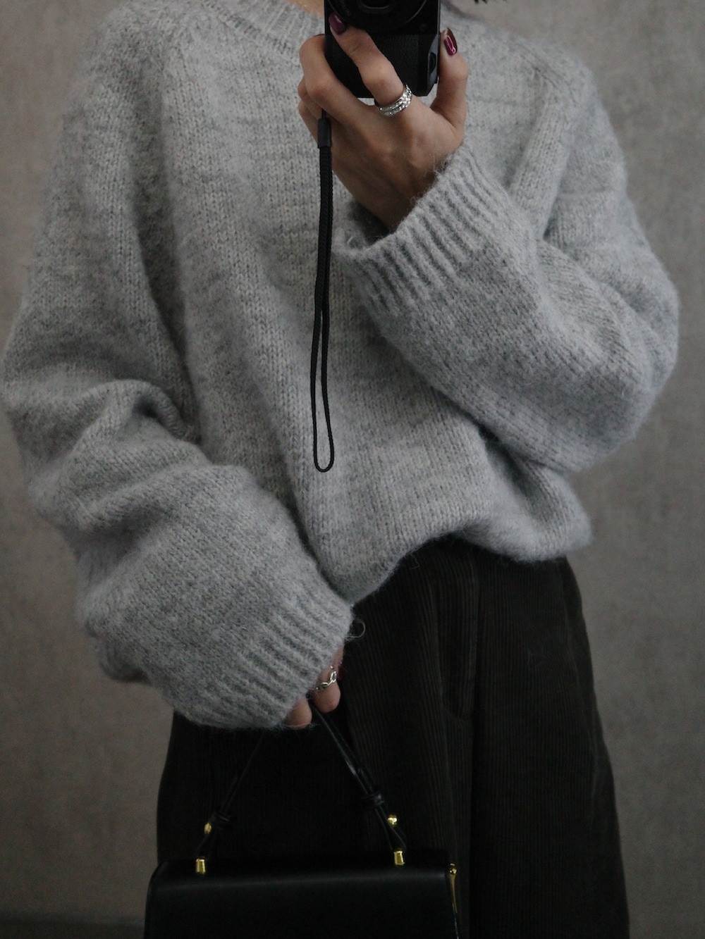 グレー系のニット/セーター、ブラック系のショルダーバッグを着用したレディースの秋コーディネートの3枚目の写真