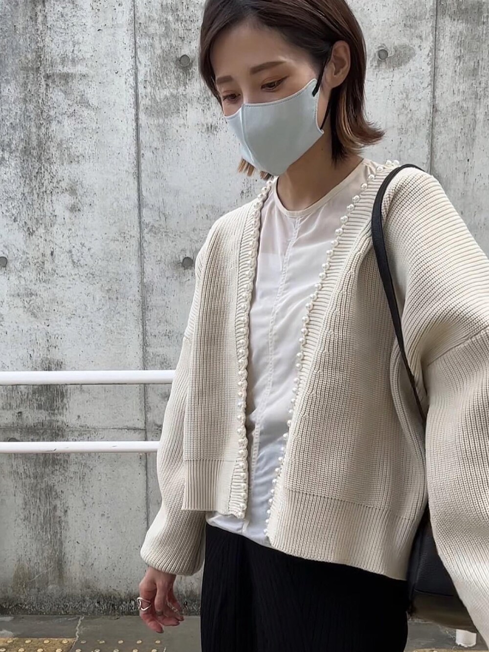 ベージュ系のカーディガン/ボレロ、ブラック系のブーツを着用したレディースの秋コーディネートの3枚目の写真