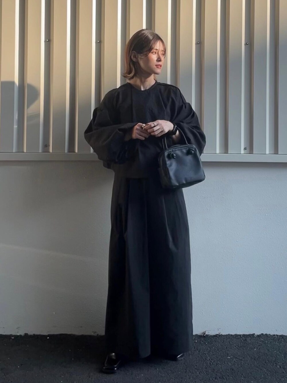 ベージュ系のワンピース、ブラック系のブーツを着用したレディースの秋コーディネートの3枚目の写真