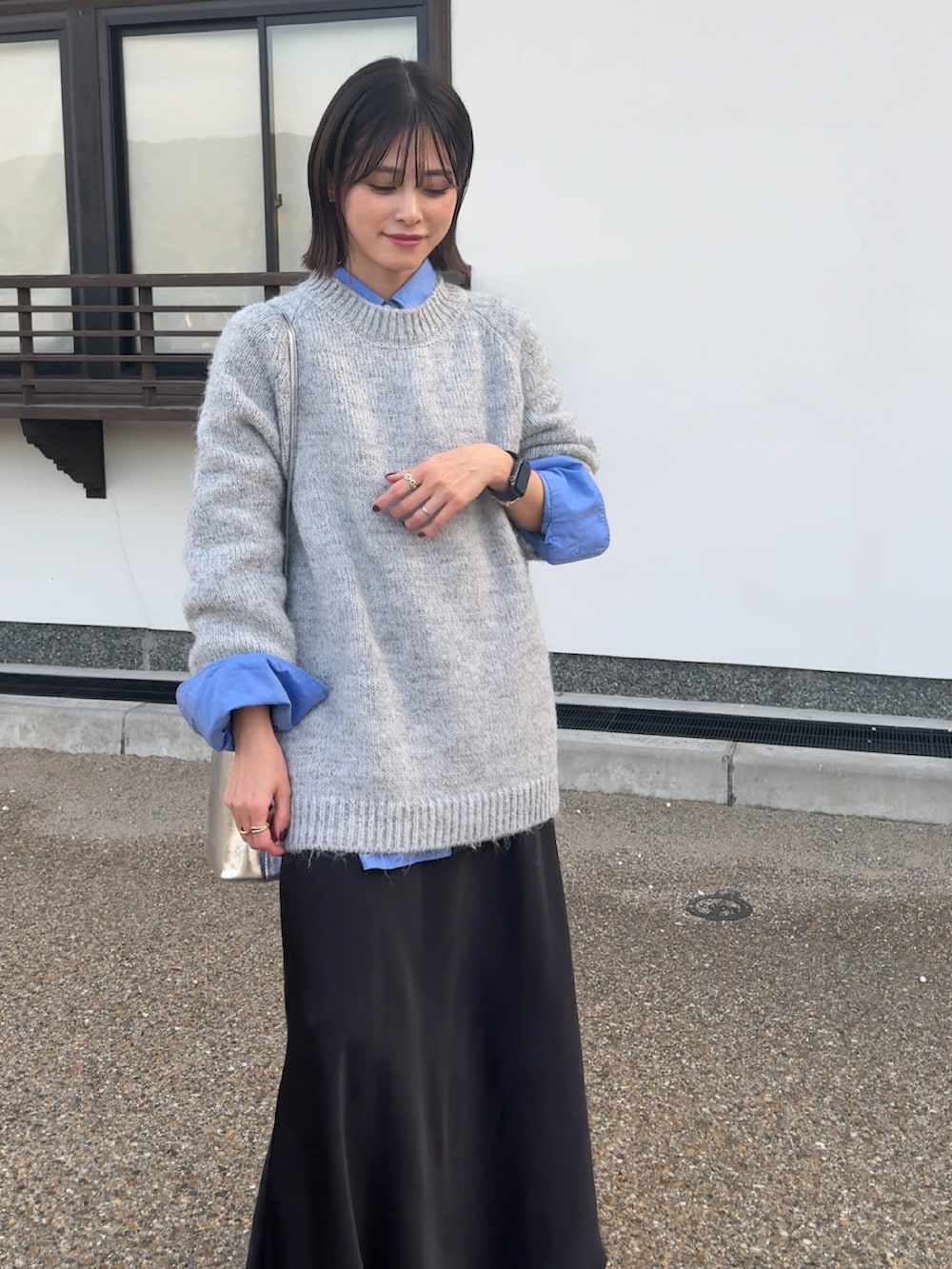 グレー系のニット/セーター、ブラック系のスカートを着用したレディースの秋コーディネートの2枚目の写真