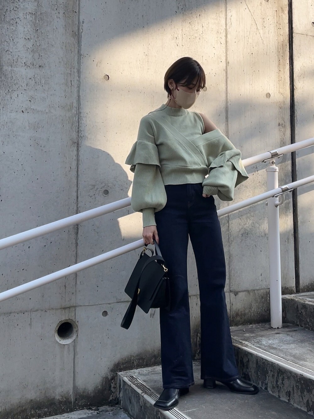 グリーン系のニット/セーター、ブラック系のブーツを着用したレディースの冬コーディネートの3枚目の写真