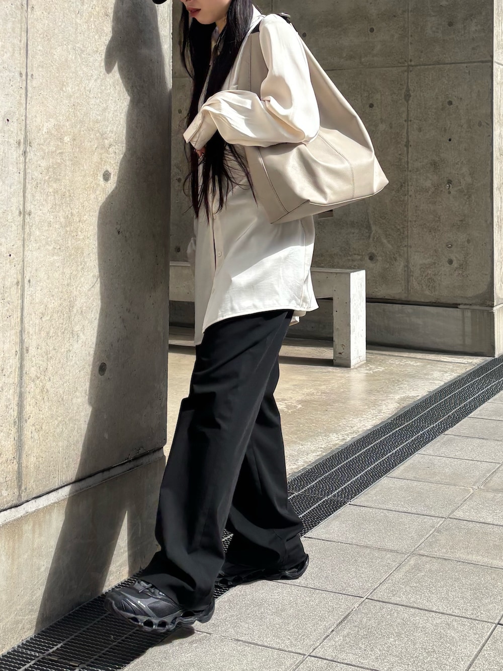 ブラック系のスニーカー、ベージュ系のショルダーバッグを着用したレディースの春コーディネートの2枚目の写真
