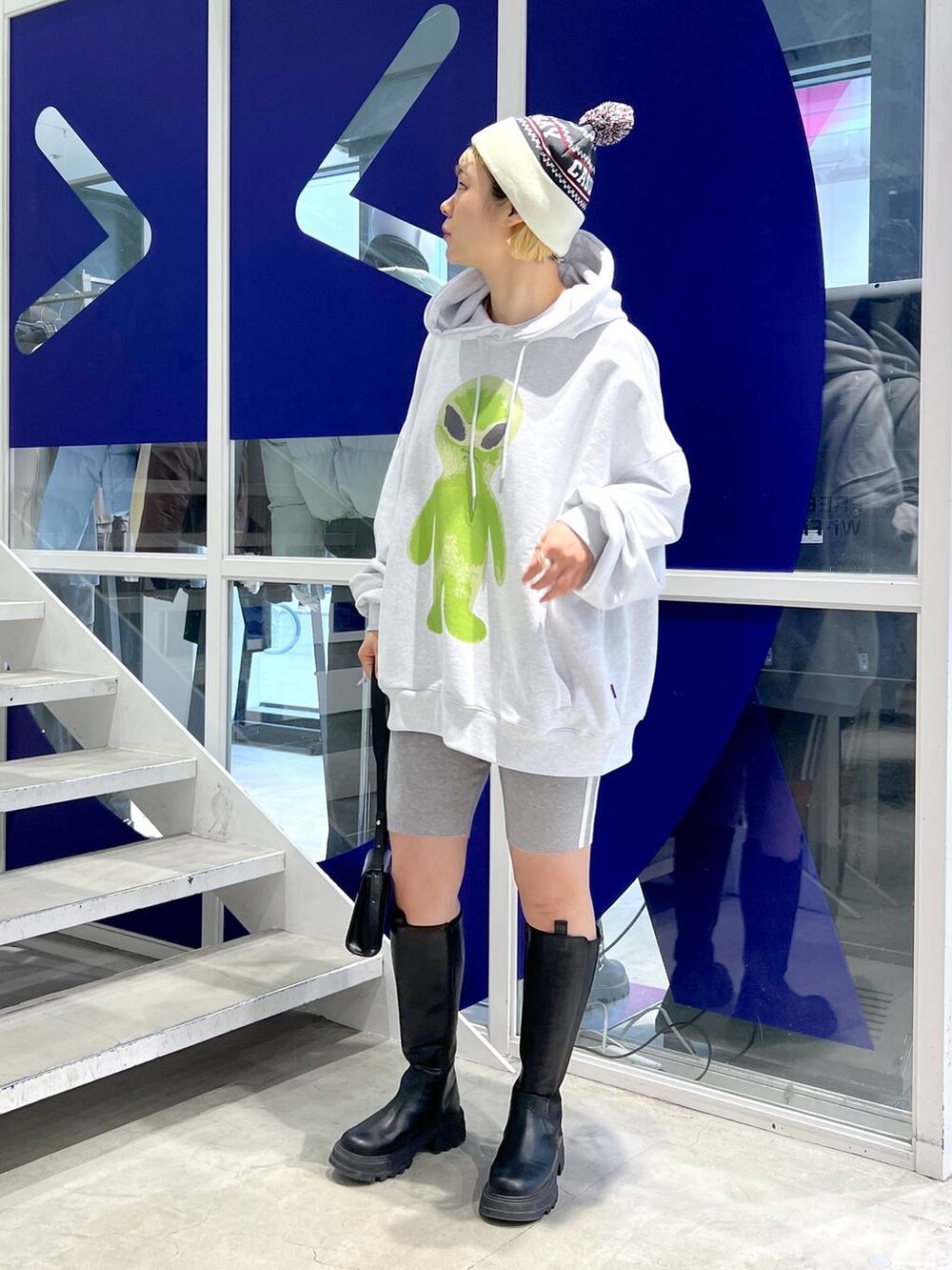 ブラック系のブーツ、ブラック系のショルダーバッグ、グレー系のパーカーを着用したレディースの秋コーディネートの9枚目の写真