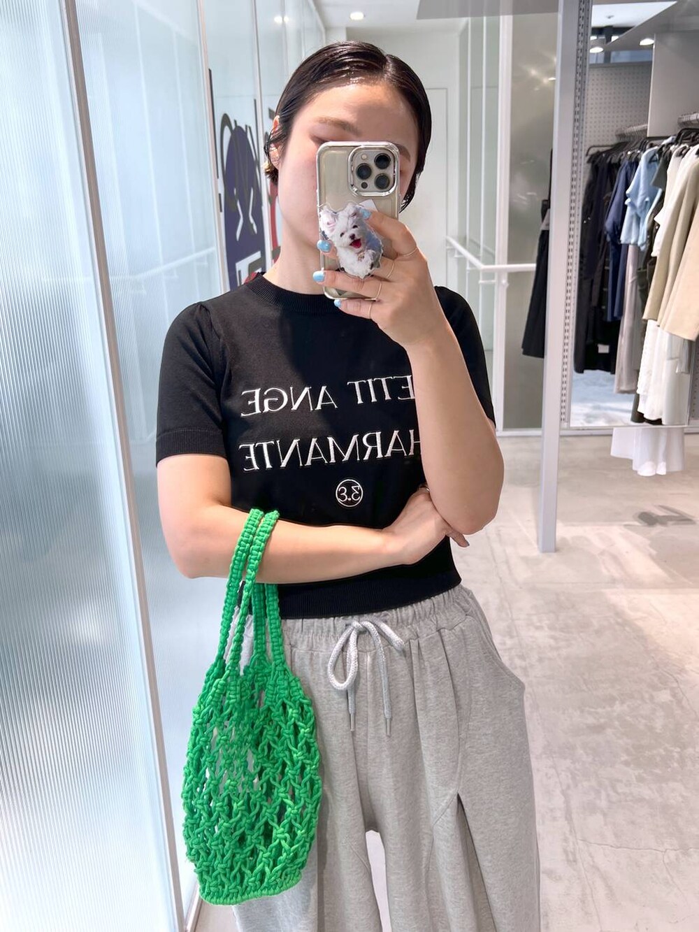 グレー系のスウェットパンツ、ブラック系のサンダル、グリーン系のトートバッグを着用したレディースの夏コーディネートの2枚目の写真