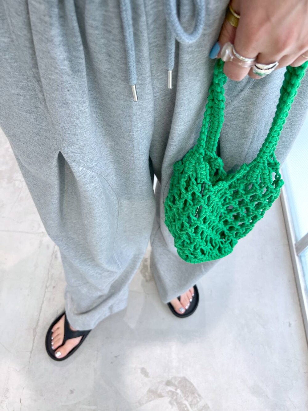 グレー系のスウェットパンツ、ブラック系のサンダル、グリーン系のトートバッグを着用したレディースの夏コーディネートの4枚目の写真