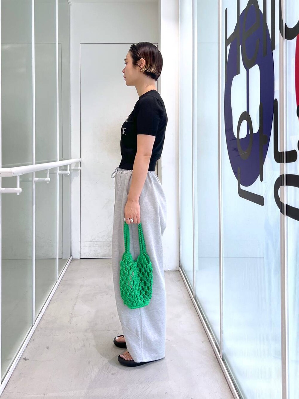 グレー系のスウェットパンツ、ブラック系のサンダル、グリーン系のトートバッグを着用したレディースの夏コーディネートの6枚目の写真