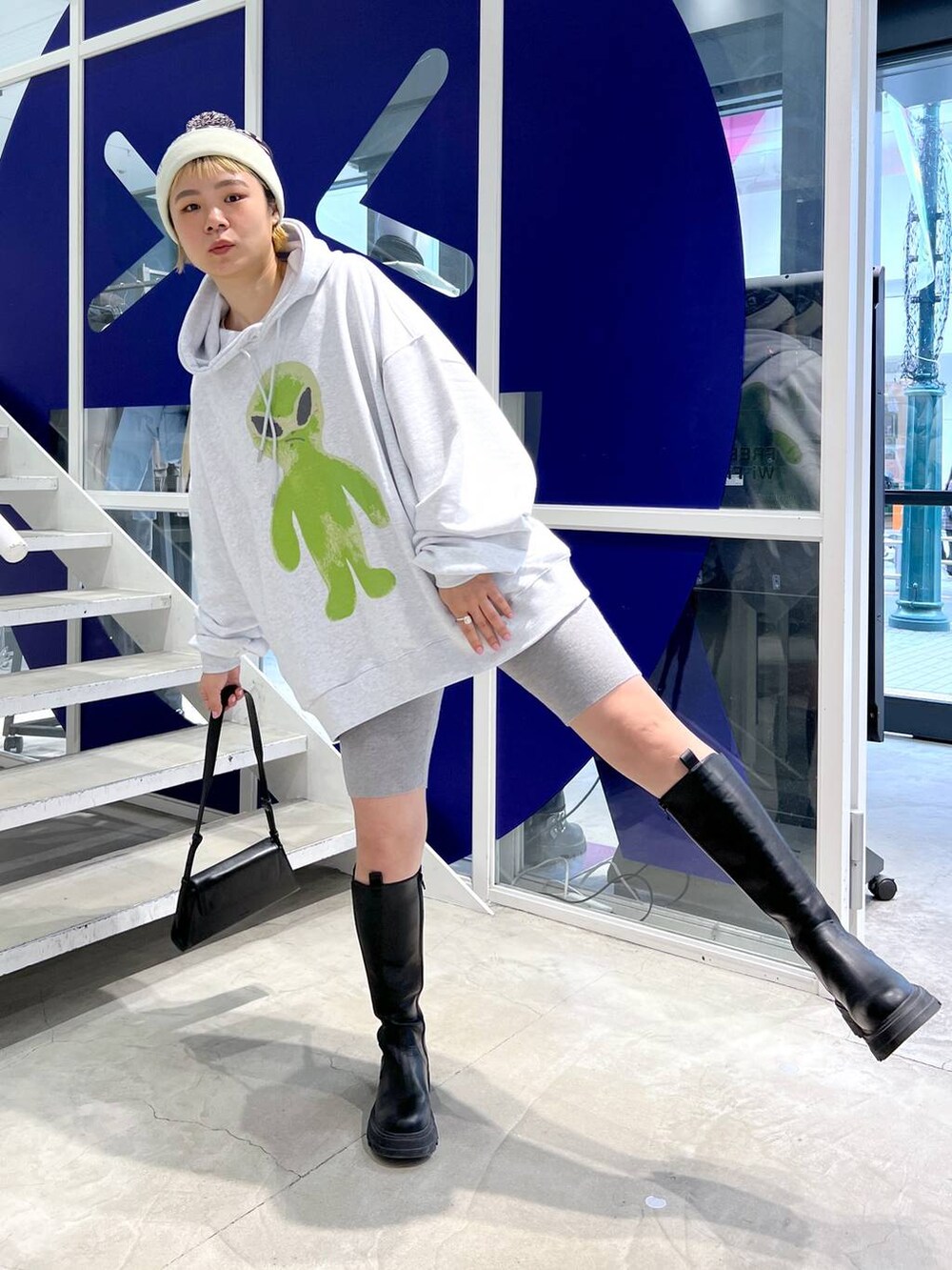 ブラック系のブーツ、ブラック系のショルダーバッグ、グレー系のパーカーを着用したレディースの秋コーディネートの2枚目の写真