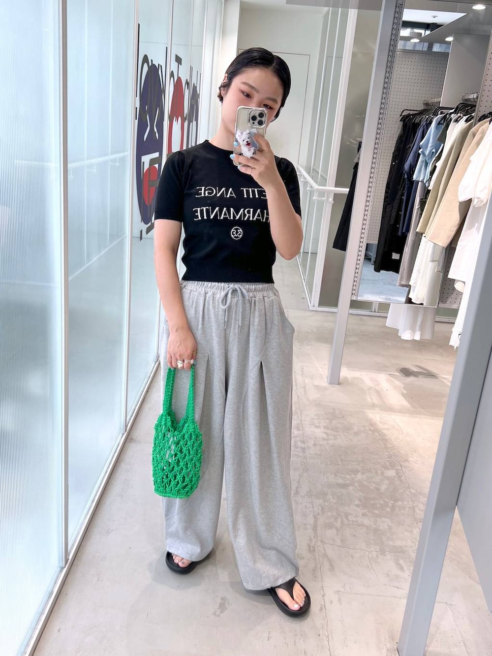 グレー系のスウェットパンツ、ブラック系のサンダル、グリーン系のトートバッグを着用したレディースの夏コーディネートの3枚目の写真