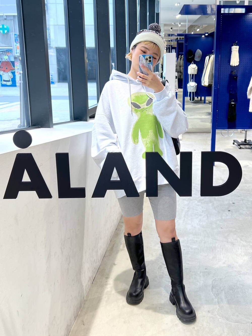 ブラック系のブーツ、ブラック系のショルダーバッグ、グレー系のパーカーを着用したレディースの秋コーディネートの8枚目の写真