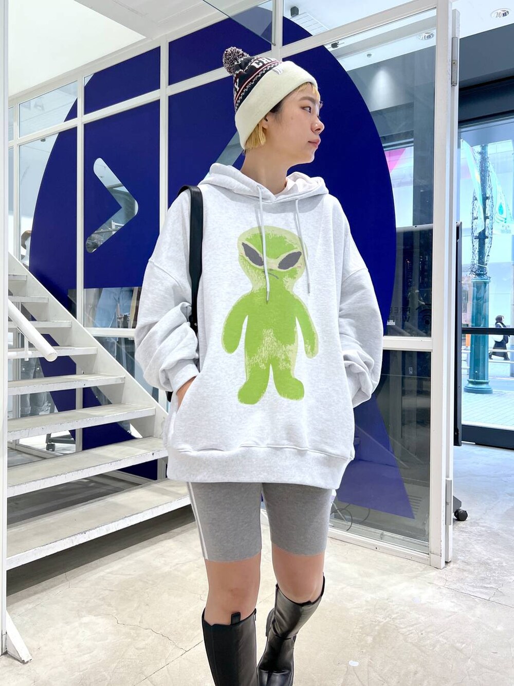 ブラック系のブーツ、ブラック系のショルダーバッグ、グレー系のパーカーを着用したレディースの秋コーディネートの6枚目の写真