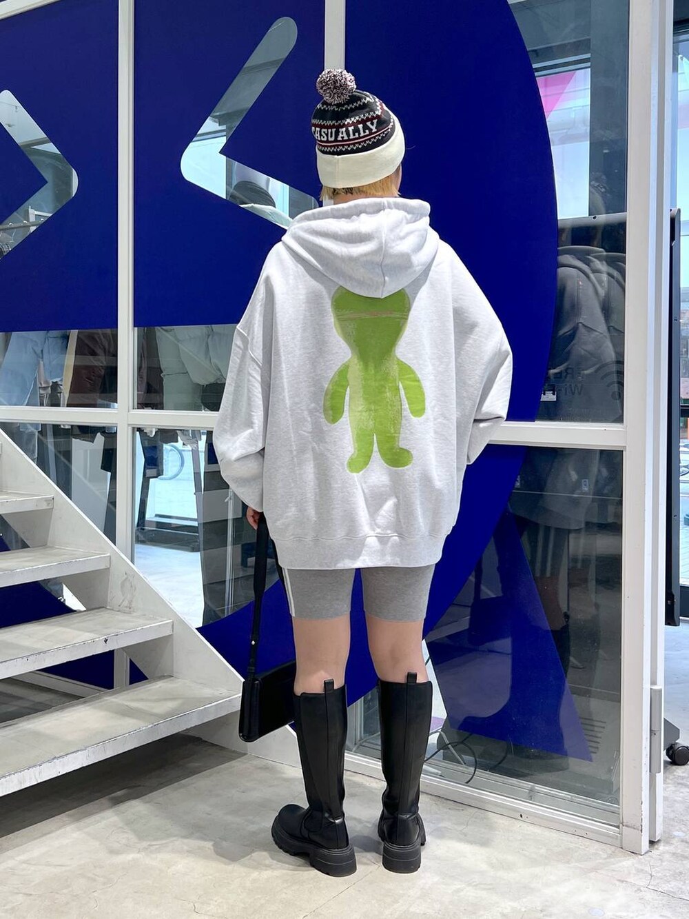 ブラック系のブーツ、ブラック系のショルダーバッグ、グレー系のパーカーを着用したレディースの秋コーディネートの3枚目の写真