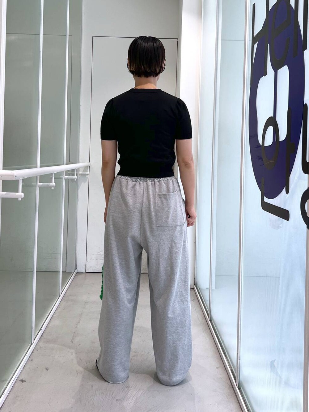 グレー系のスウェットパンツ、ブラック系のサンダル、グリーン系のトートバッグを着用したレディースの夏コーディネートの7枚目の写真