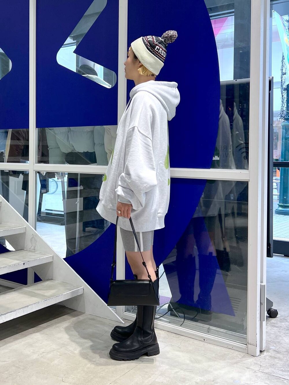 ブラック系のブーツ、ブラック系のショルダーバッグ、グレー系のパーカーを着用したレディースの秋コーディネートの4枚目の写真