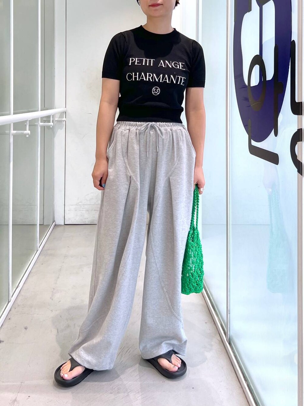 グレー系のスウェットパンツ、ブラック系のサンダル、グリーン系のトートバッグを着用したレディースの夏コーディネートの8枚目の写真