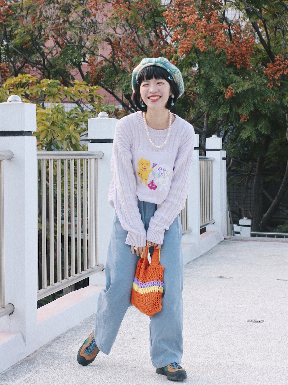 パープル系のトップス、ブルー系のパンツ、イエロー系のシューズを着用したレディースの冬コーディネートの2枚目の写真