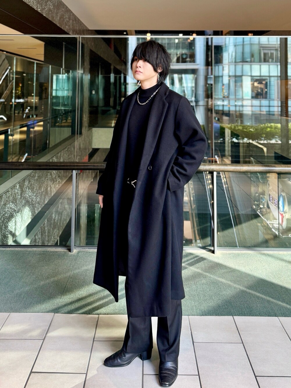 ブラック系のチェスターコート、ブラック系のドレスシューズ、ブラック系のニット/セーターを着用したメンズの冬コーディネートの2枚目の写真