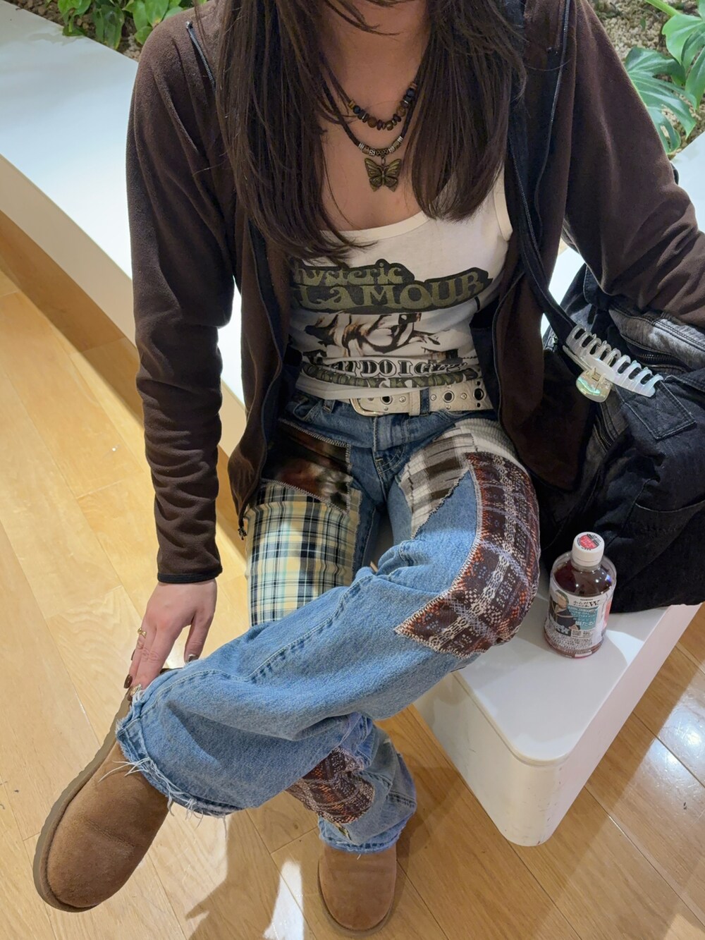 ホワイト系のタンクトップ、ブルー系のデニムパンツ、ベージュ系のブーツを着用したレディースの秋コーディネートの2枚目の写真