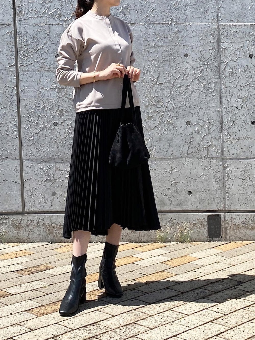 ベージュ系のブルゾン、ブラック系のトートバッグ、ブラック系のスカートを着用したレディースの秋コーディネートの2枚目の写真