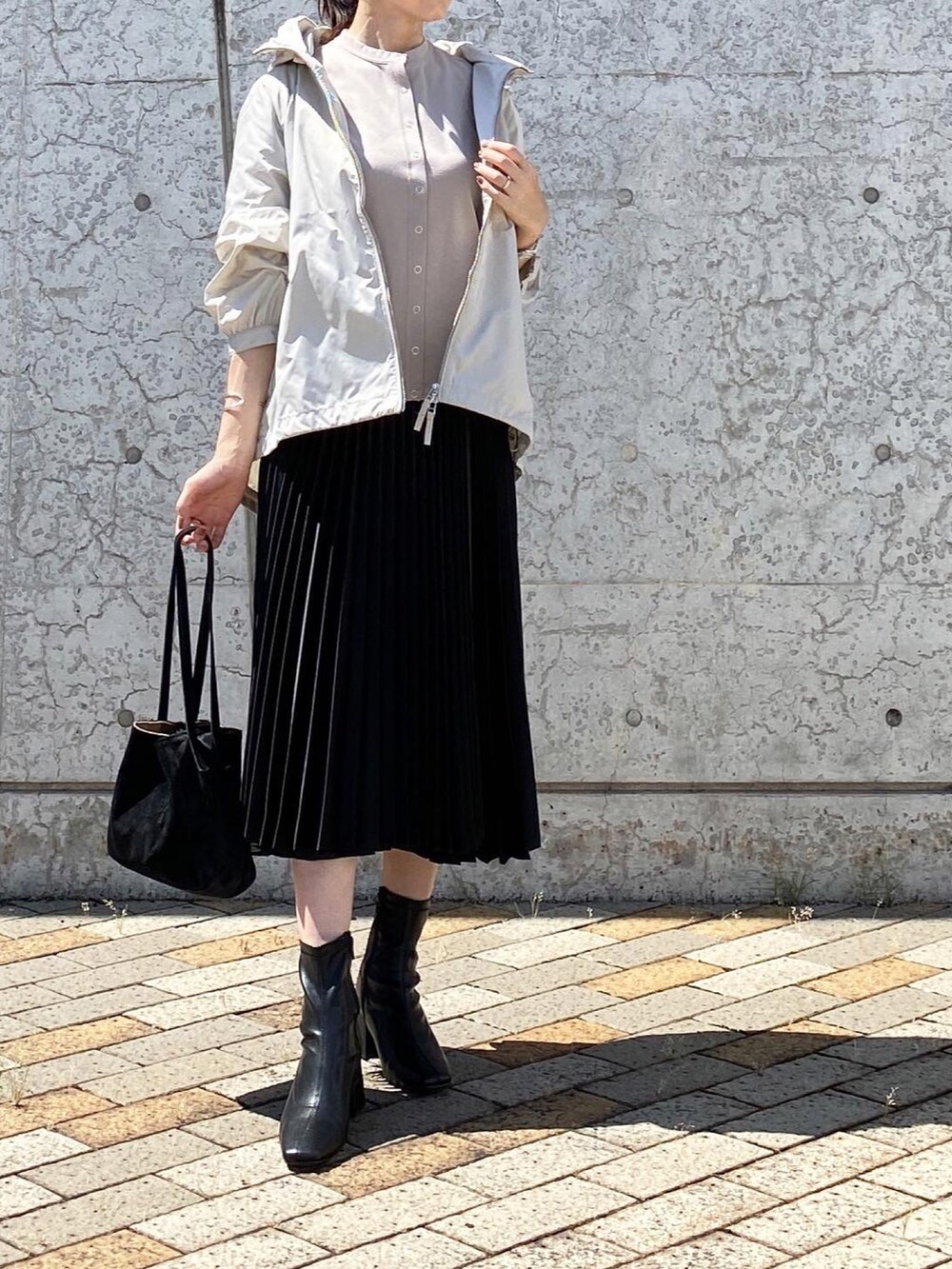 ベージュ系のブルゾン、ブラック系のトートバッグ、ブラック系のスカートを着用したレディースの秋コーディネートの3枚目の写真