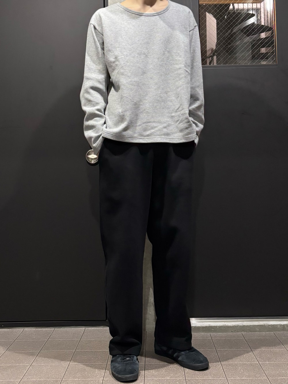 ブラック系のスウェットパンツ、グレー系のTシャツ/カットソー、ブラック系のスニーカーを着用したメンズの春コーディネートの2枚目の写真