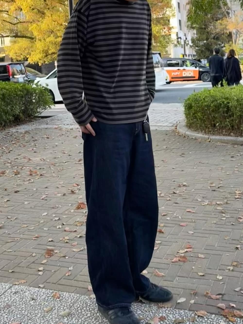 ブラック系のTシャツ/カットソー、ブルー系のデニムパンツ、ブラック系のスニーカーを着用したメンズの春コーディネートの2枚目の写真