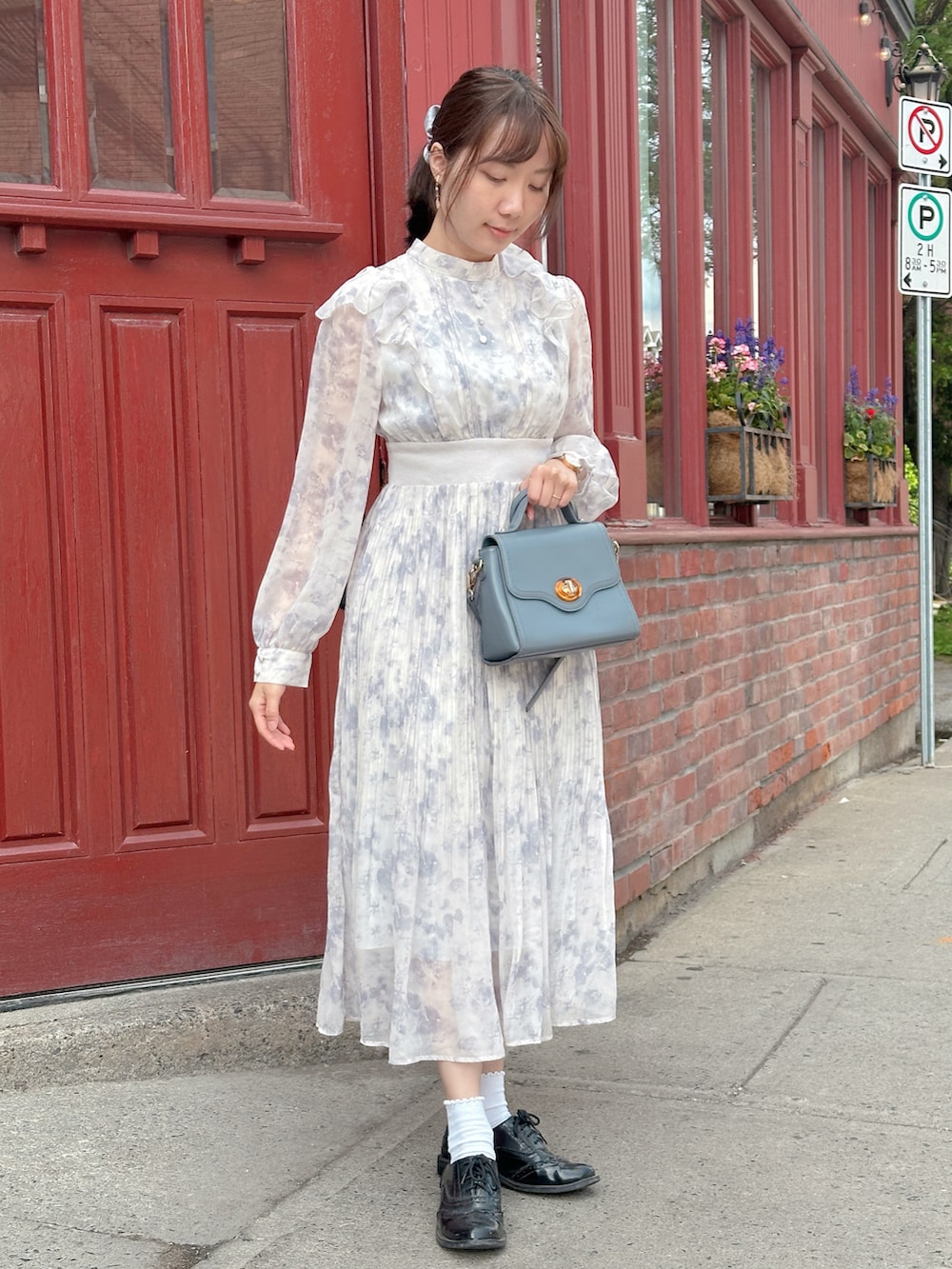 ブルー系のワンピース、ブルー系のショルダーバッグ、ブラック系のドレスシューズを着用したレディースの夏コーディネートの3枚目の写真