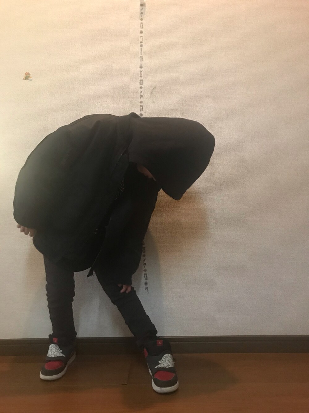 ブラック系のパーカー、ブラック系のブルゾン、グレー系のその他パンツを着用したキッズの冬コーディネートの2枚目の写真