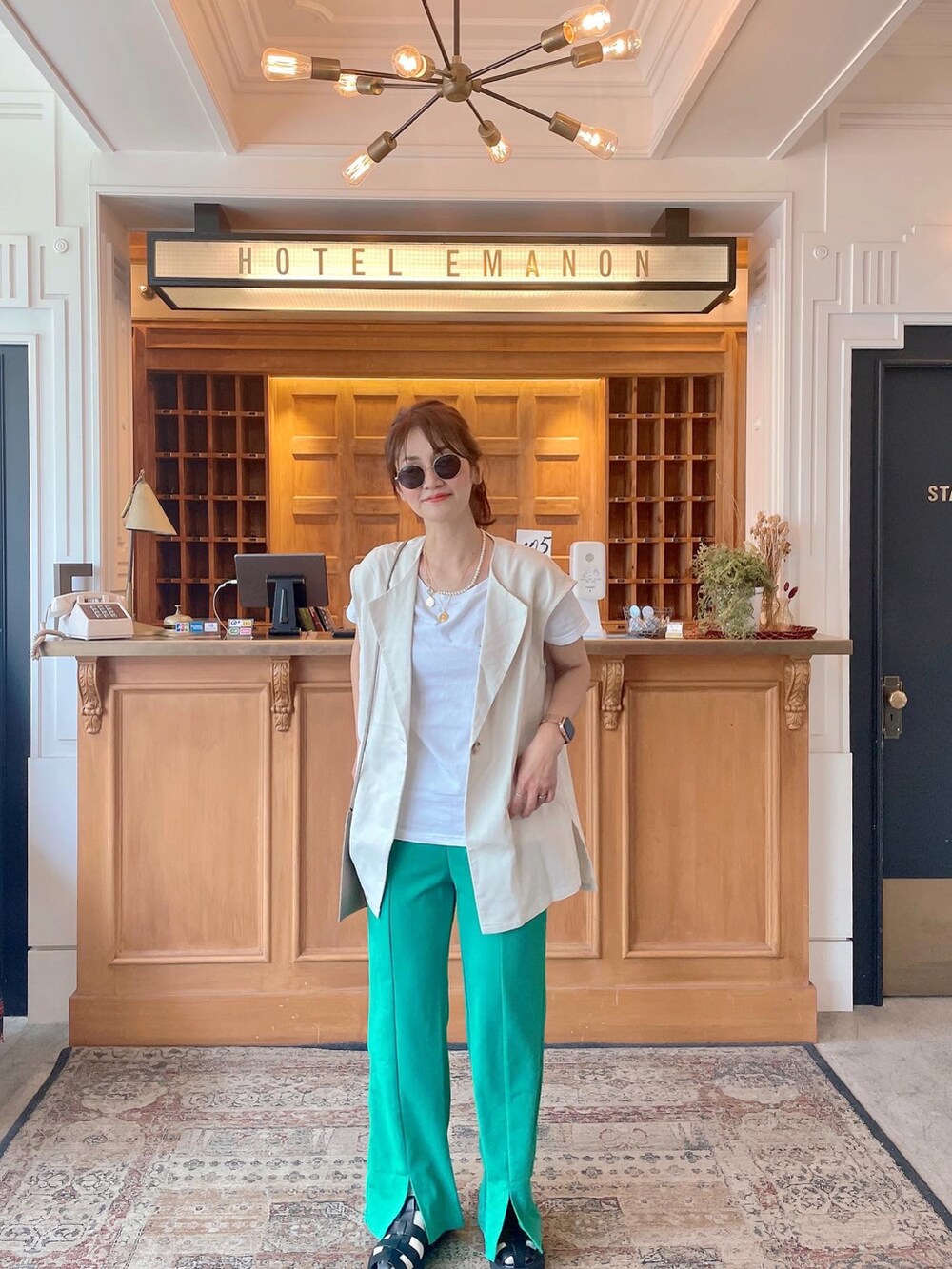 ホワイト系のTシャツ/カットソー、ブラック系のサンダル、ベージュ系のその他アウターを着用したレディースの秋コーディネートの2枚目の写真