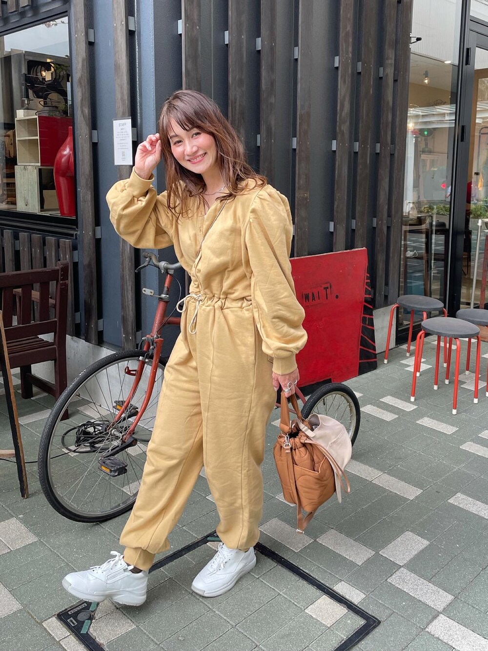 ホワイト系のスニーカー、ベージュ系のオールインワン・サロペットを着用したレディースの春コーディネートの2枚目の写真