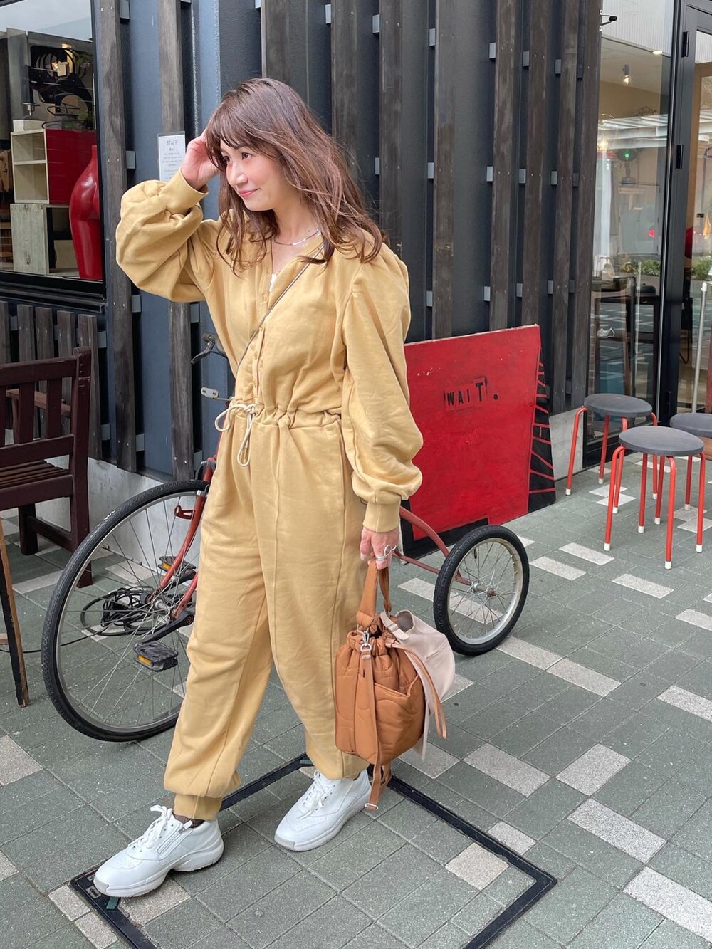 ホワイト系のスニーカー、ベージュ系のオールインワン・サロペットを着用したレディースの春コーディネートの3枚目の写真