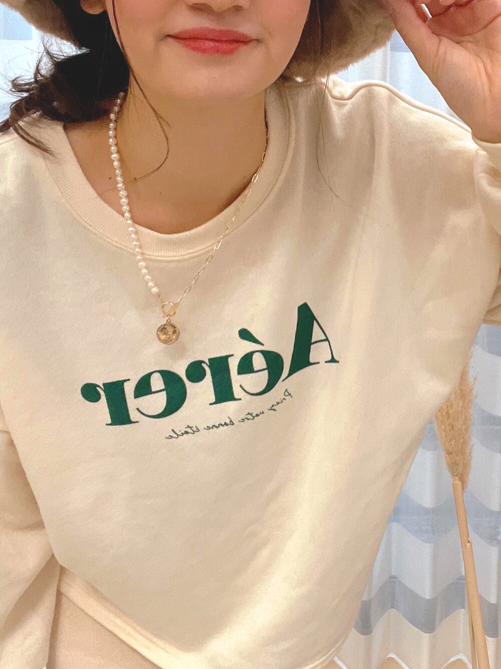 ベージュ系のスウェット、ホワイト系のスカート、ゴールド系のデジタル腕時計を着用したレディースの冬コーディネートの3枚目の写真