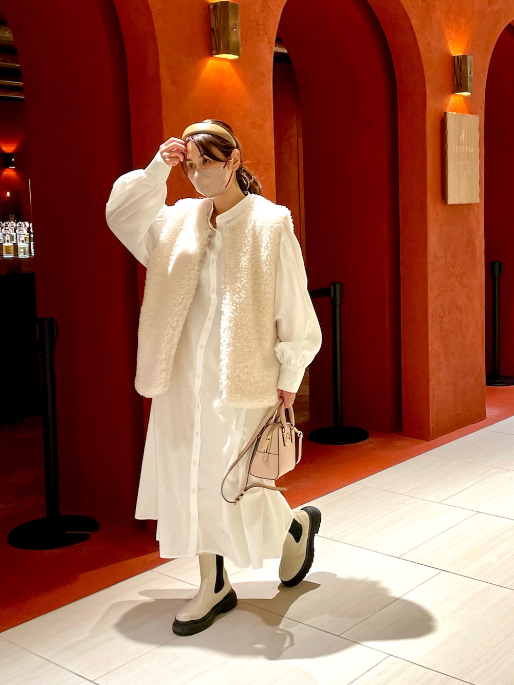 ホワイト系のブーツ、ホワイト系のシャツワンピース、ピンク系のショルダーバッグを着用したレディースの秋コーディネートの2枚目の写真