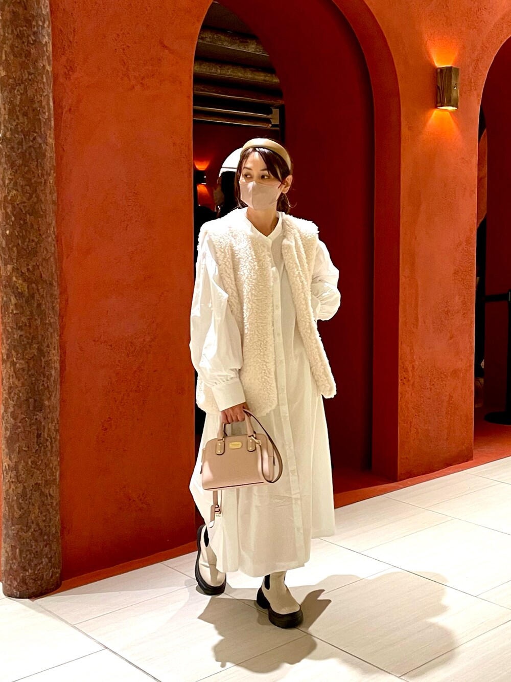 ホワイト系のブーツ、ホワイト系のシャツワンピース、ピンク系のショルダーバッグを着用したレディースの秋コーディネートの3枚目の写真