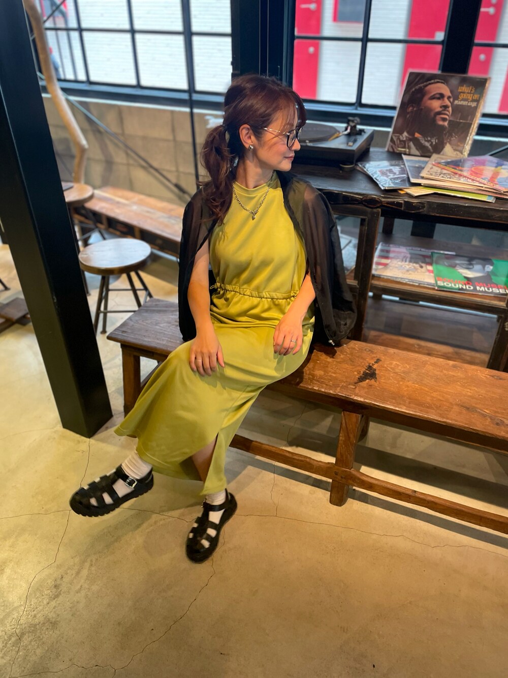 ブラック系のサンダル、イエロー系のワンピース、ブラック系のブルゾンを着用したレディースの秋コーディネートの3枚目の写真