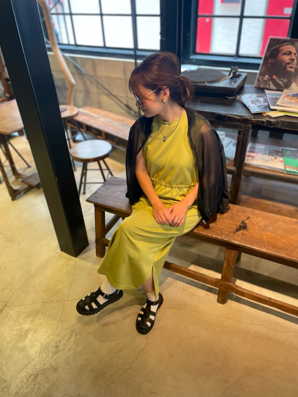 ブラック系のサンダル、イエロー系のワンピース、ブラック系のブルゾンを着用したレディースの秋コーディネートの2枚目の写真