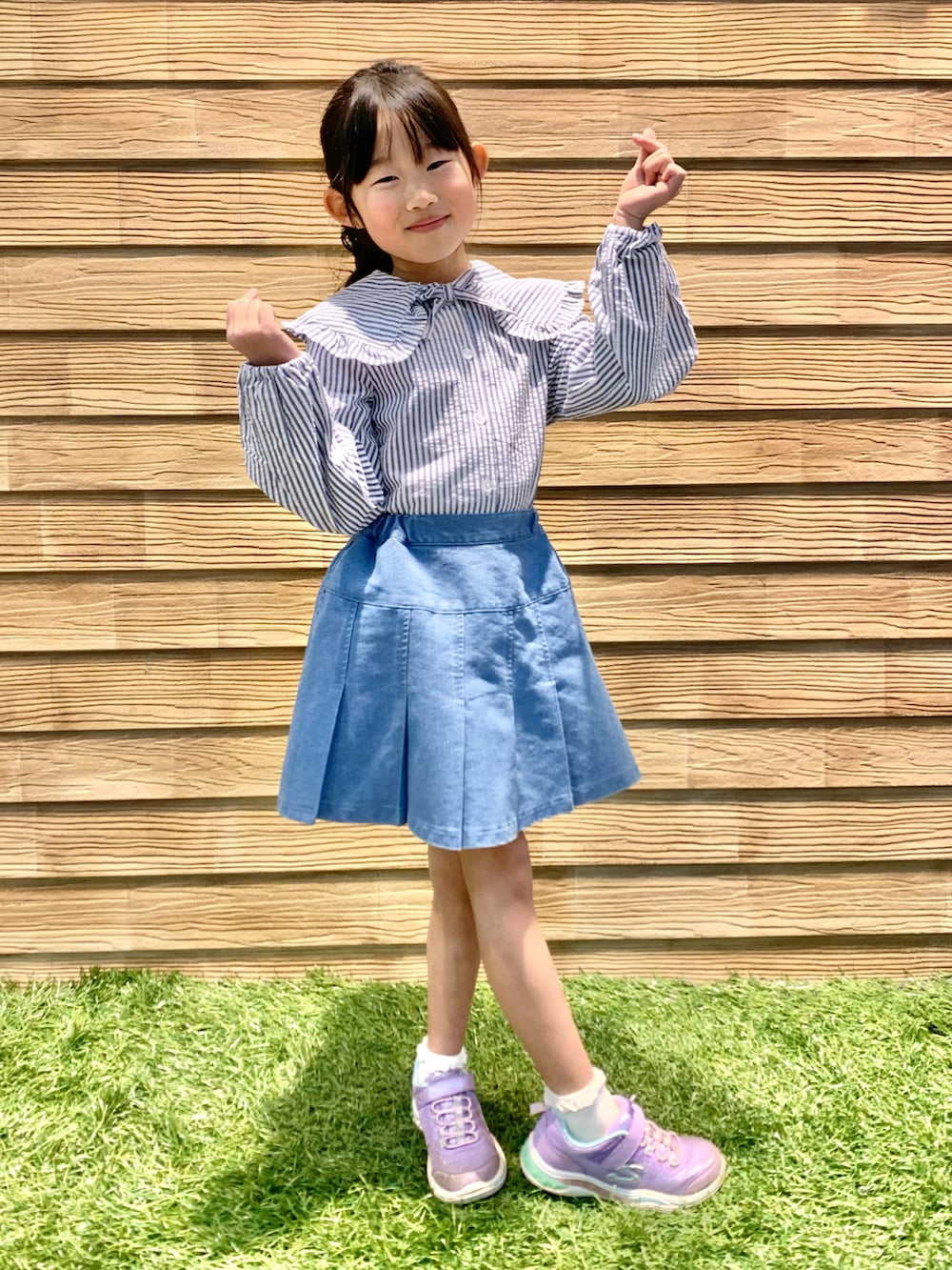 ブルー系のシャツ/ブラウス、ブルー系のデニムスカート、パープル系のトートバッグを着用したキッズの春コーディネートの2枚目の写真