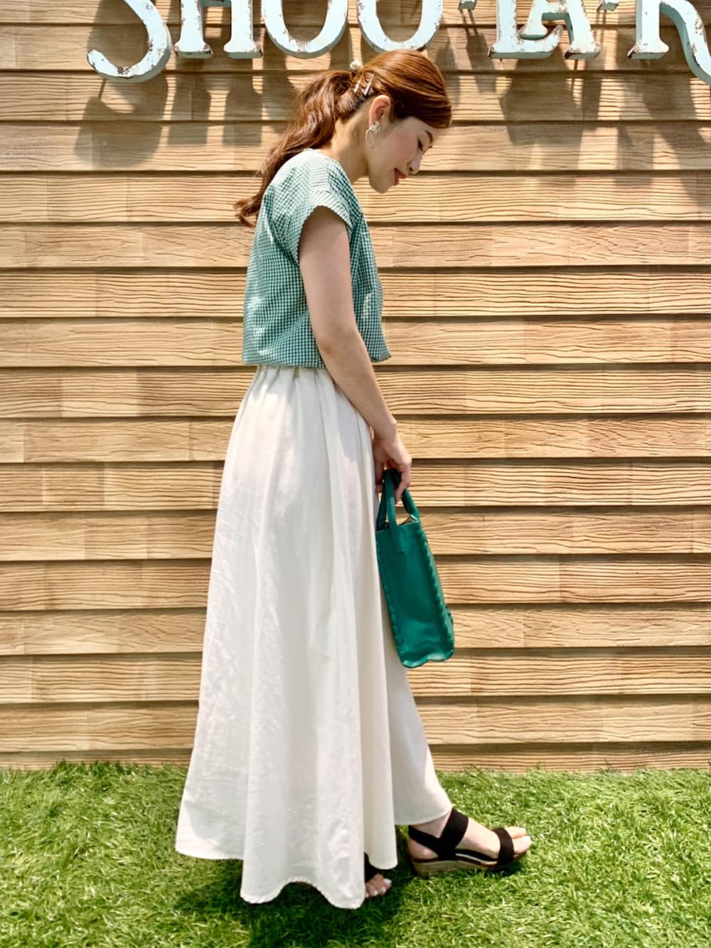 グリーン系のシャツ/ブラウス、ホワイト系のスカート、グリーン系のショルダーバッグを着用したレディースの夏コーディネートの4枚目の写真