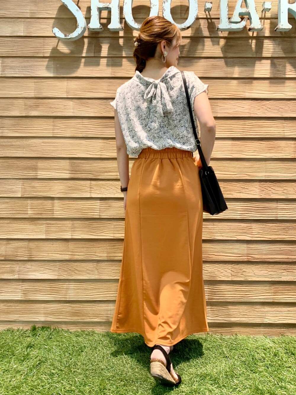 ホワイト系のシャツ/ブラウス、オレンジ系のスカート、ブラック系のショルダーバッグを着用したレディースの秋コーディネートの5枚目の写真