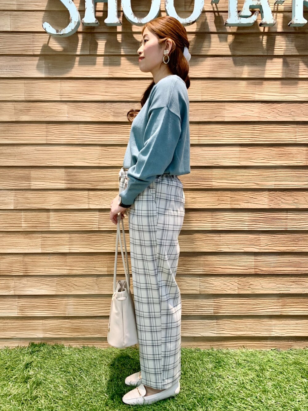 グリーン系のニット/セーター、グレー系のその他パンツ、ホワイト系のトートバッグを着用したレディースの冬コーディネートの4枚目の写真