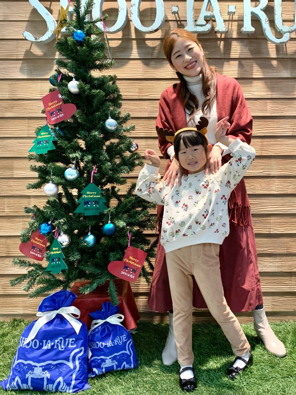 ホワイト系のニット/セーター、レッド系のスカート、ホワイト系のブーツを着用したレディースの冬コーディネートの2枚目の写真