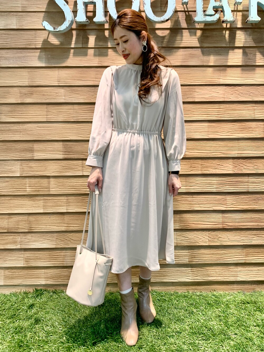 ブルー系のニット/セーター、ベージュ系のワンピース、ホワイト系のショルダーバッグを着用したレディースの冬コーディネートの5枚目の写真