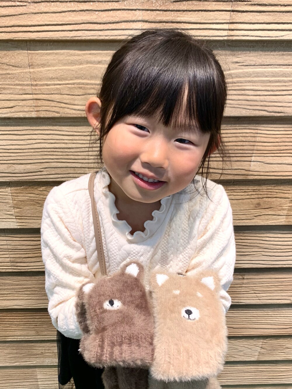 ベージュ系のワンピース、ブラック系のその他パンツ、ベージュ系の手袋を着用したキッズの冬コーディネートの3枚目の写真