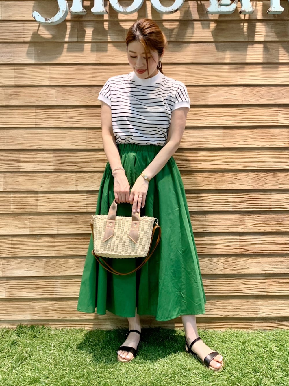 ブラック系のTシャツ/カットソー、グリーン系のスカート、ホワイト系のショルダーバッグを着用したレディースの夏コーディネートの3枚目の写真