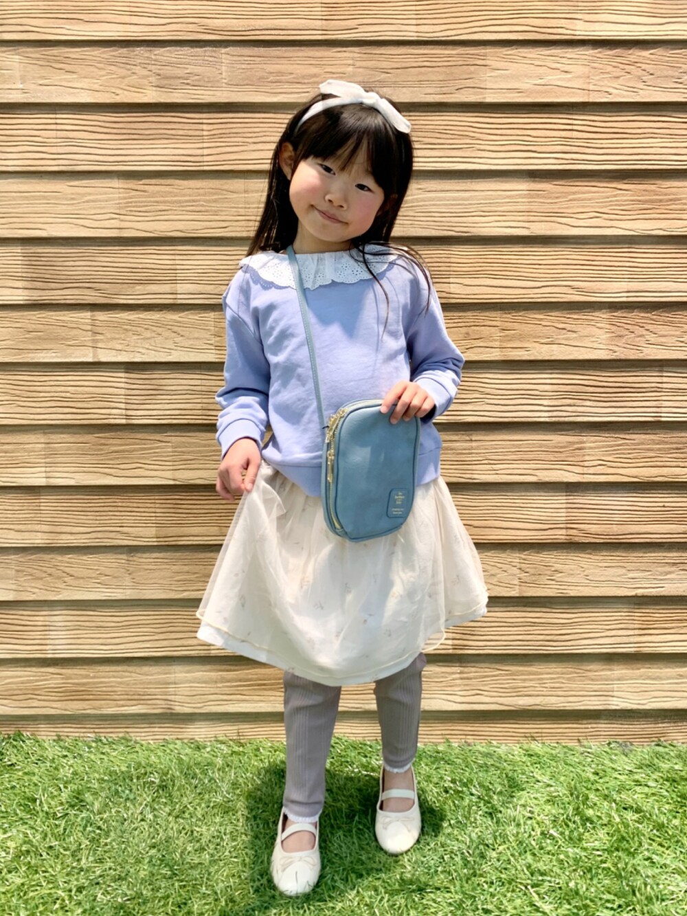 ブルー系のスウェット、ホワイト系のスカート、ブラウン系のその他パンツを着用したキッズの春コーディネートの2枚目の写真