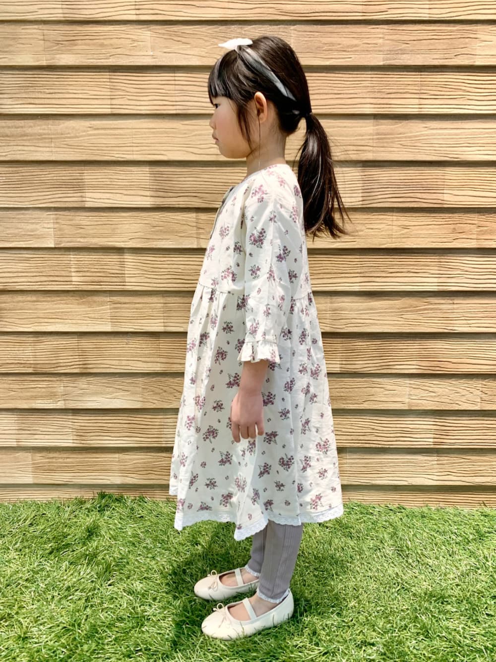 ベージュ系のワンピース、ブラウン系のその他パンツ、グリーン系のラッピングキットを着用したキッズの春コーディネートの3枚目の写真