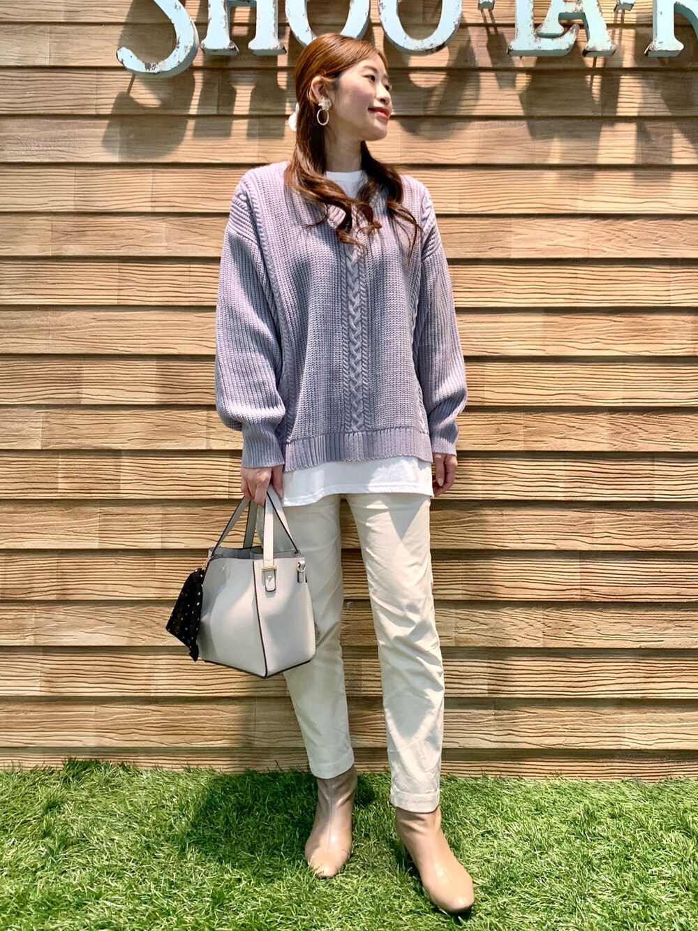 パープル系のニット/セーター、ホワイト系のその他パンツ、グレー系のトートバッグを着用したレディースの冬コーディネートの2枚目の写真