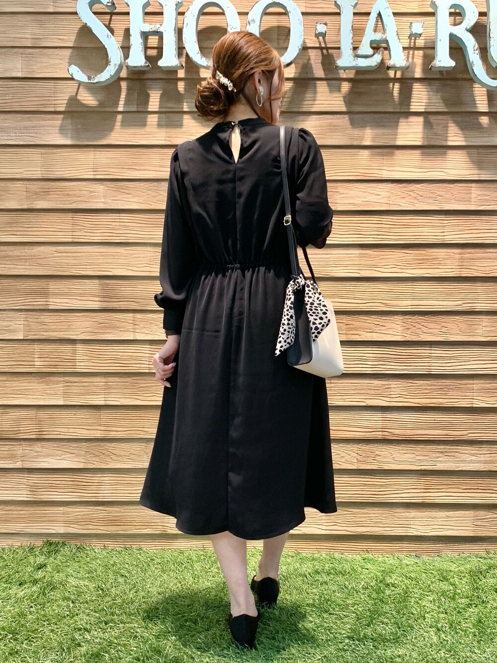 ブラック系のワンピース、ブラック系のショルダーバッグ、ブラック系のパンプスを着用したレディースの冬コーディネートの4枚目の写真