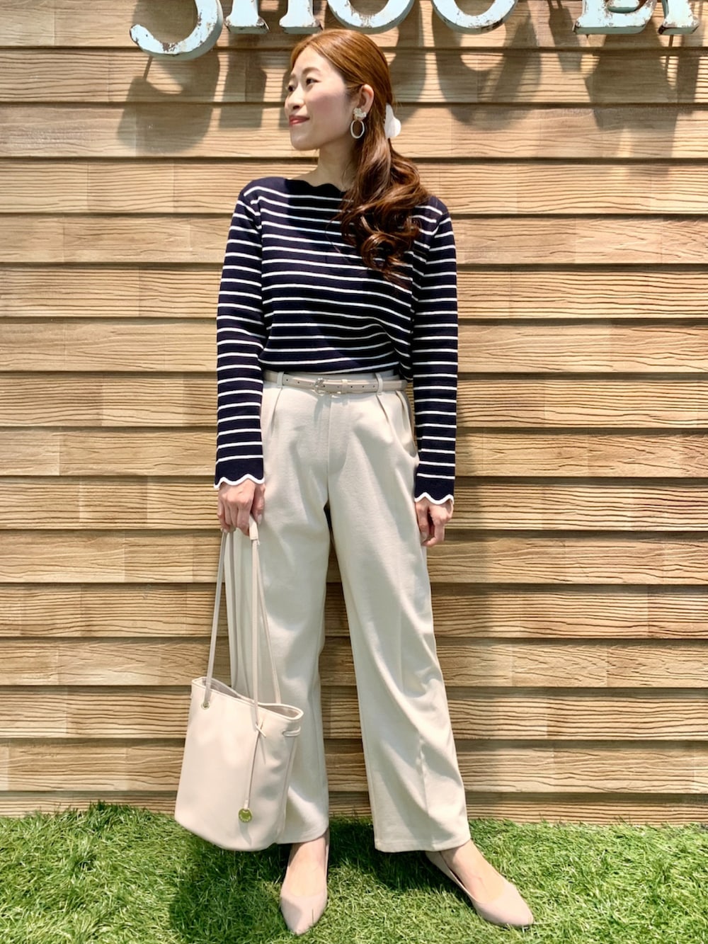ブルー系のニット/セーター、ホワイト系のその他パンツ、ホワイト系のトートバッグを着用したレディースの春コーディネートの2枚目の写真