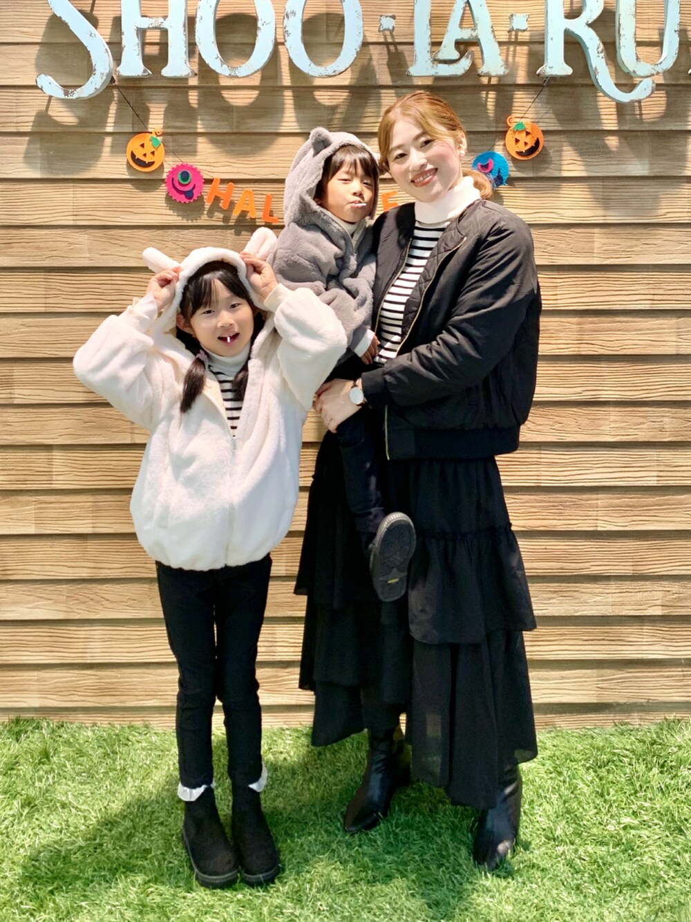 ブラック系のブルゾン、ホワイト系のニット/セーター、ブラック系のスカートを着用したレディースの秋コーディネートの2枚目の写真